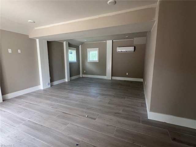 basement with hardwood / wood-style floors and an AC wall unit