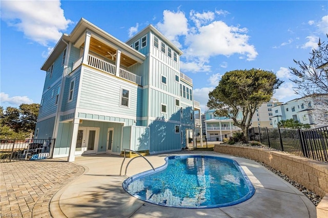 view of swimming pool featuring a patio area, french doors, and fence