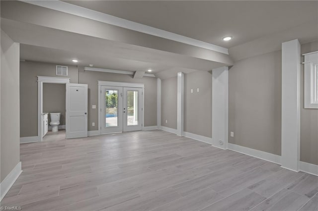 spare room featuring french doors and light hardwood / wood-style floors