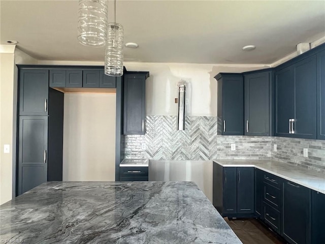 kitchen with tasteful backsplash, light stone countertops, and pendant lighting