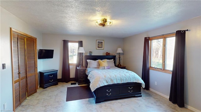 bedroom featuring multiple windows, a closet, and a textured ceiling