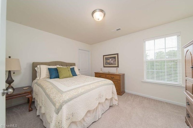 bedroom with light carpet and baseboards