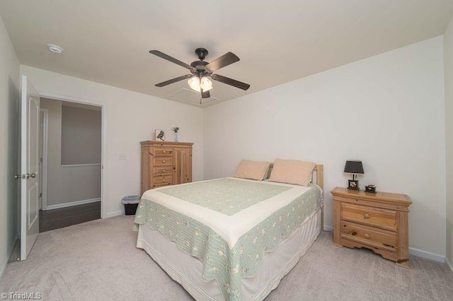 bedroom featuring light colored carpet, baseboards, and ceiling fan