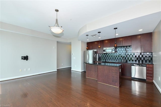 201 N Elm St Unit 310, Greensboro, NC 27401 - kitchen featuring stainless steel appliances, dark countertops, a kitchen island, backsplash, and dark wood-style flooring