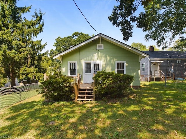 rear view of property featuring a wooden deck and a yard