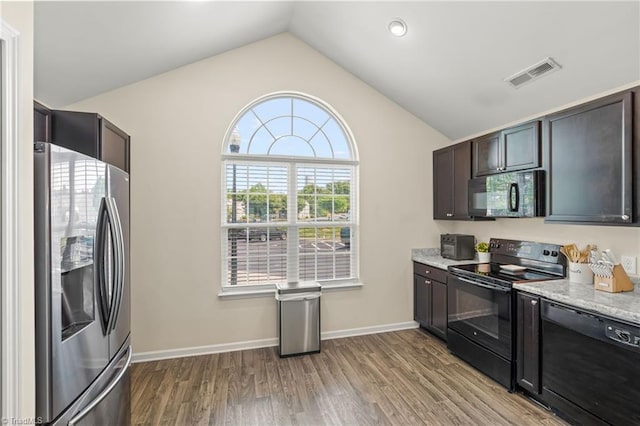 kitchen with lofted ceiling, light wood-type flooring, black appliances, visible vents, and baseboards