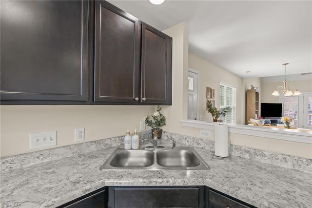 kitchen with a sink, plenty of natural light, light countertops, and dark brown cabinets
