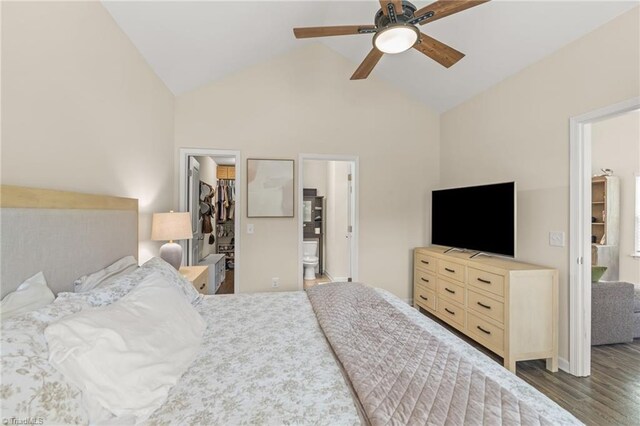 bedroom with connected bathroom, wood finished floors, high vaulted ceiling, a closet, and a walk in closet