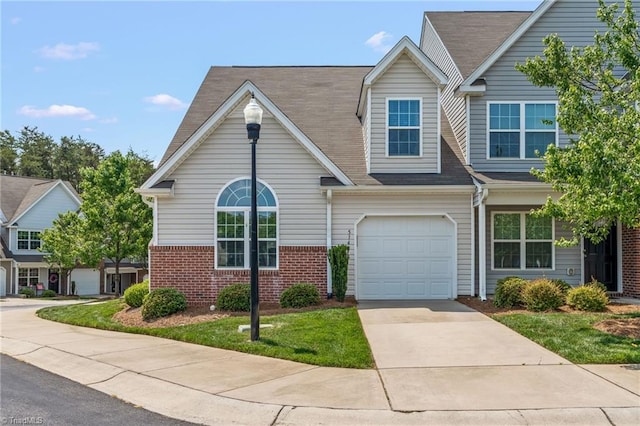 view of front of house featuring driveway, brick siding, and an attached garage