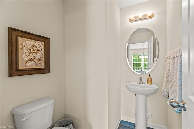 bathroom with toilet and baseboards