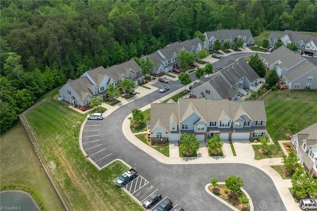 drone / aerial view with a wooded view and a residential view