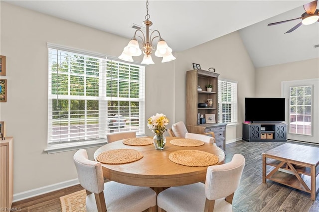 dining area featuring wood finished floors, ceiling fan with notable chandelier, visible vents, baseboards, and vaulted ceiling