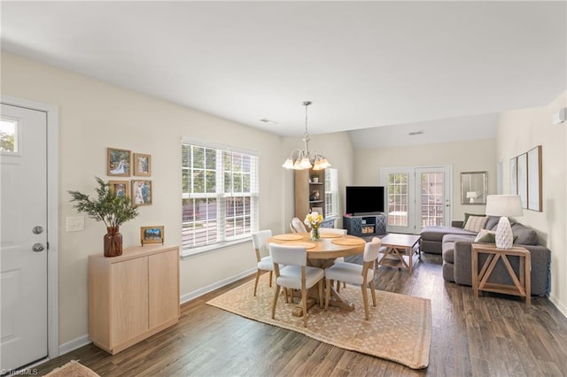 dining space with an inviting chandelier, dark wood-type flooring, and baseboards