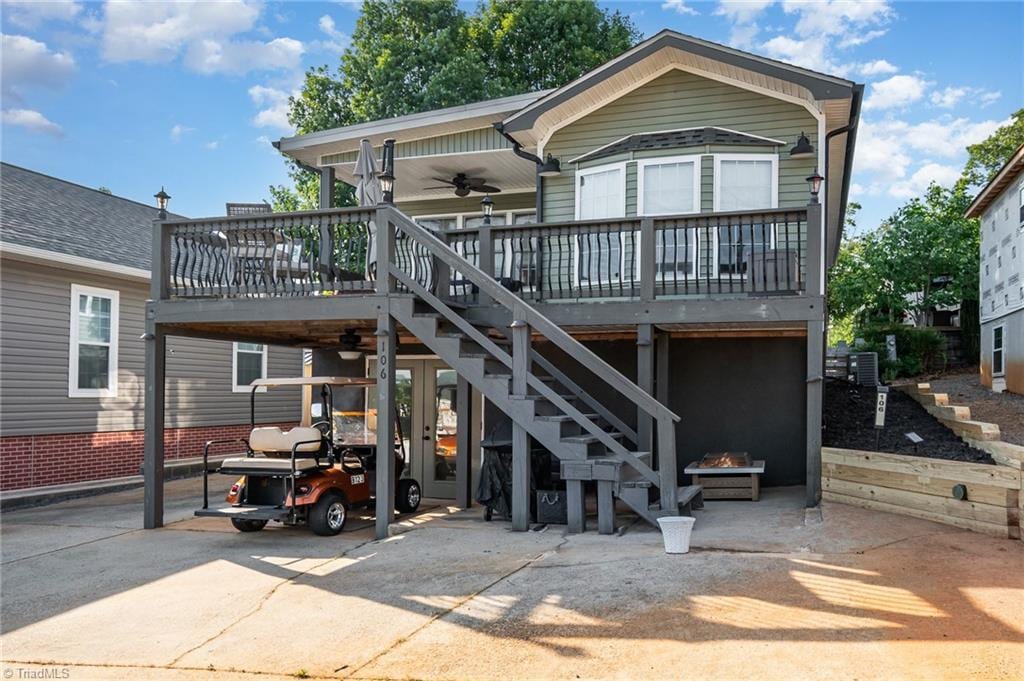 106 Dare Ln, New London, NC 28127 - back of property featuring stairs, a fire pit, ceiling fan, a carport, and central AC