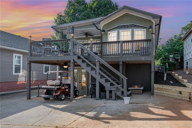 rear view of property featuring stairway, an outdoor fire pit, ceiling fan, cooling unit, and a wooden deck