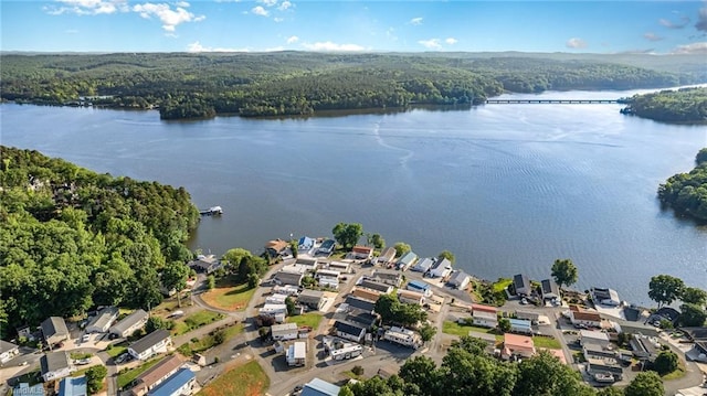 drone / aerial view of a heavily wooded area and a nearby body of water