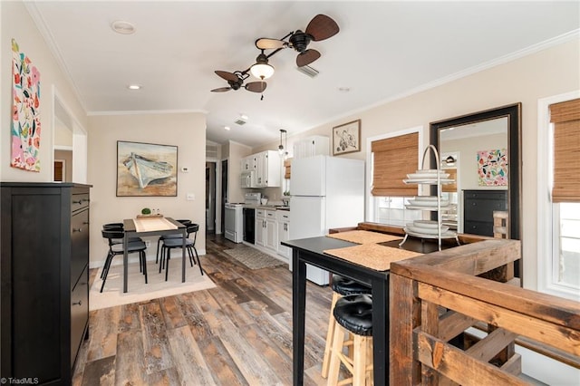 kitchen with a ceiling fan, white appliances, white cabinetry, dark wood-type flooring, and crown molding