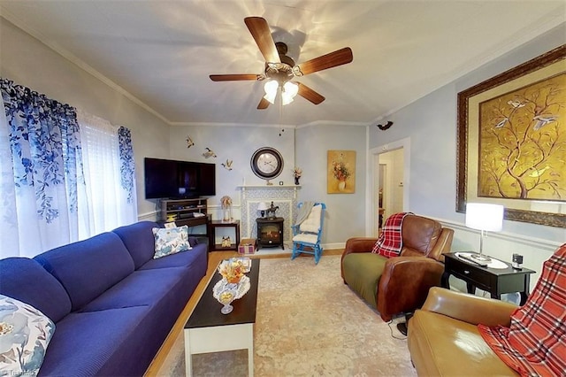 living room featuring a wood stove, ceiling fan, and crown molding