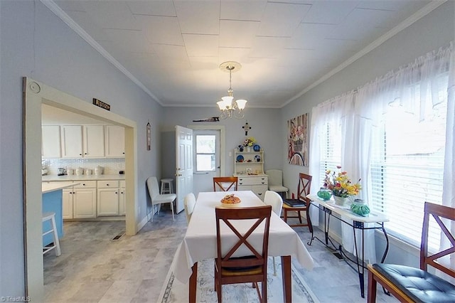 dining space featuring a notable chandelier and crown molding