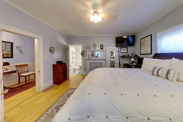 bedroom featuring ensuite bath, wood-type flooring, ceiling fan, and crown molding