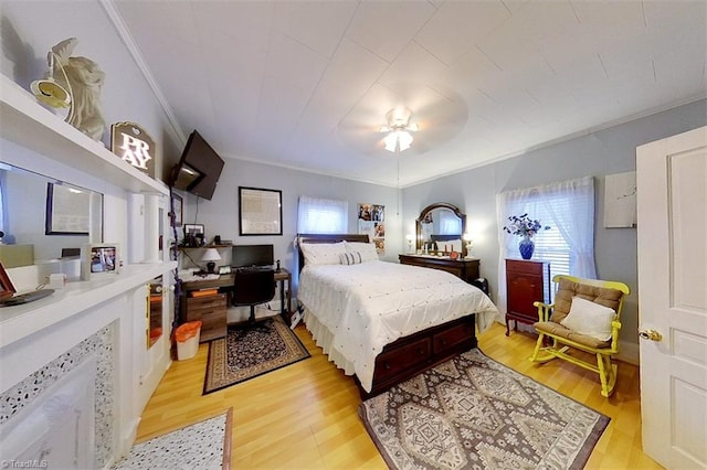 bedroom with light wood-type flooring, ceiling fan, and crown molding