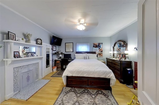 bedroom featuring ornamental molding, ceiling fan, and light hardwood / wood-style flooring