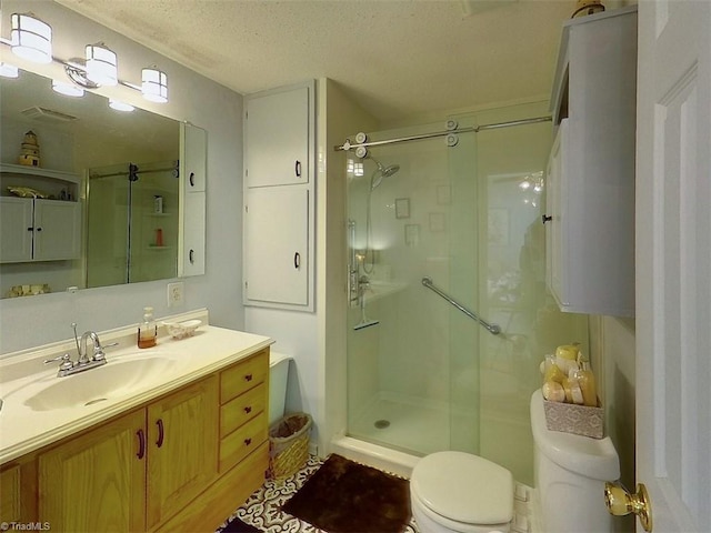 bathroom with walk in shower, vanity, a textured ceiling, and toilet