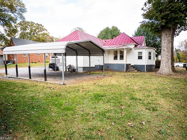 back of house featuring a lawn and a carport