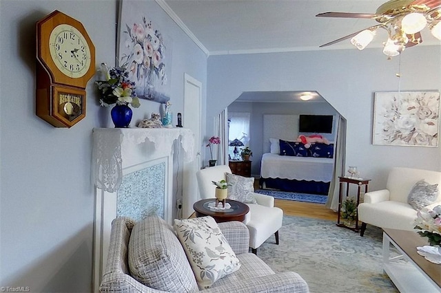 living area with ornamental molding, light hardwood / wood-style floors, and ceiling fan