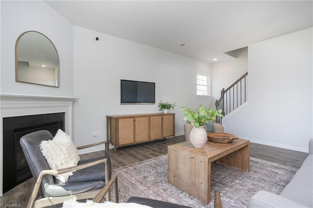 living room with baseboards, a fireplace, wood finished floors, and stairway