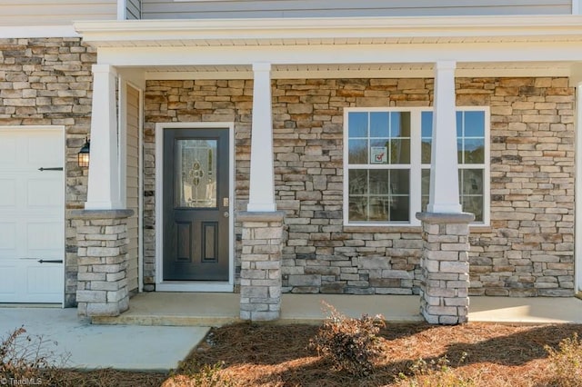 doorway to property with covered porch and stone siding