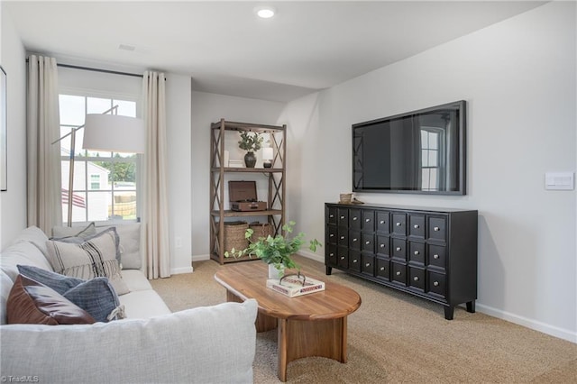 carpeted living area with recessed lighting and baseboards