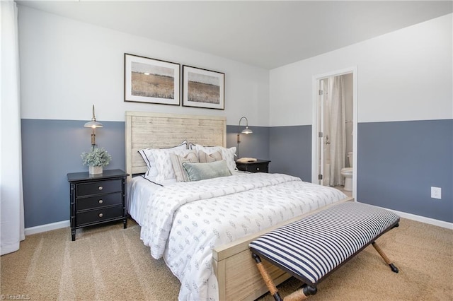 carpeted bedroom with baseboards and ensuite bath