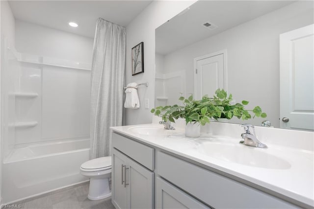 bathroom with a sink, toilet, double vanity, and visible vents