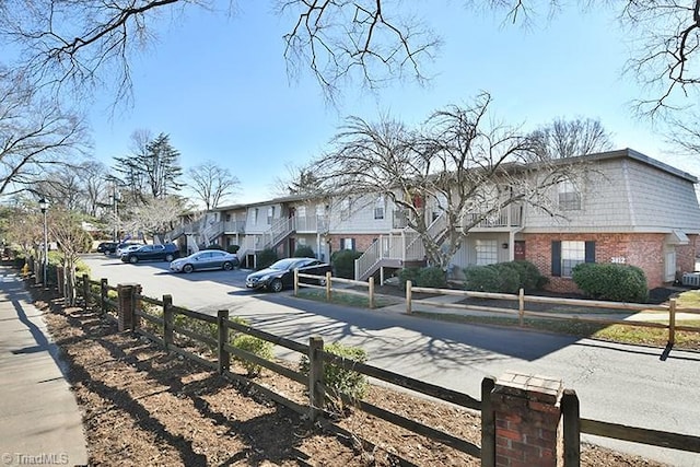 view of front facade with a fenced front yard, a residential view, and brick siding