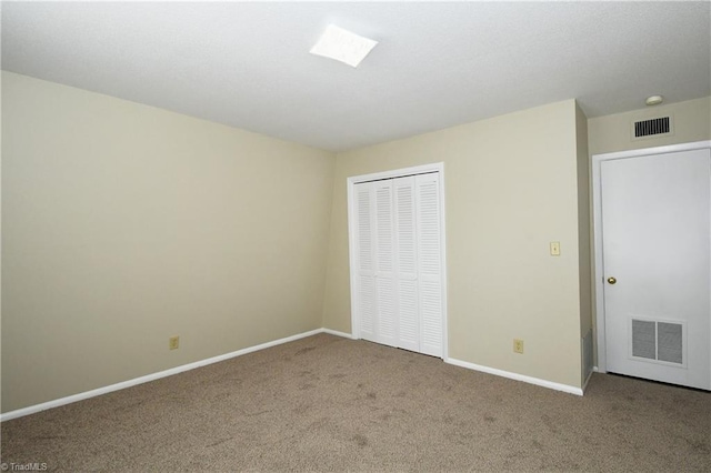 unfurnished bedroom with a closet, visible vents, baseboards, and carpet