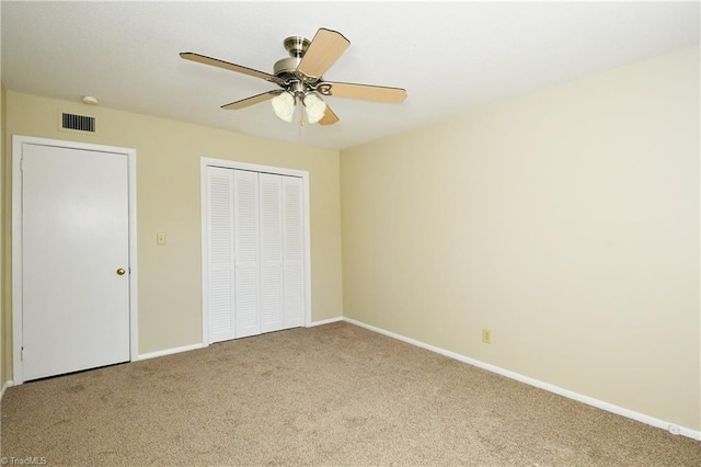 unfurnished bedroom with visible vents, a ceiling fan, a closet, carpet flooring, and baseboards