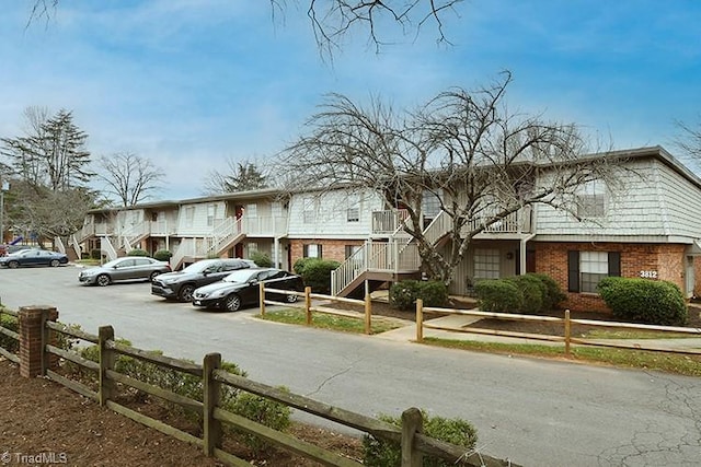 view of front facade featuring a fenced front yard, brick siding, and a residential view