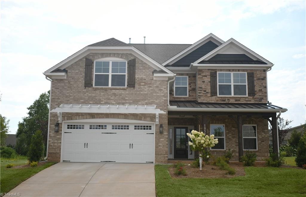 craftsman house featuring a garage and a front lawn