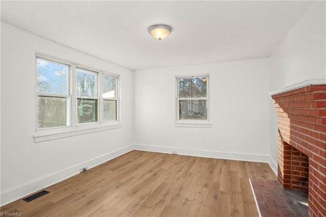 interior space with a brick fireplace and hardwood / wood-style flooring