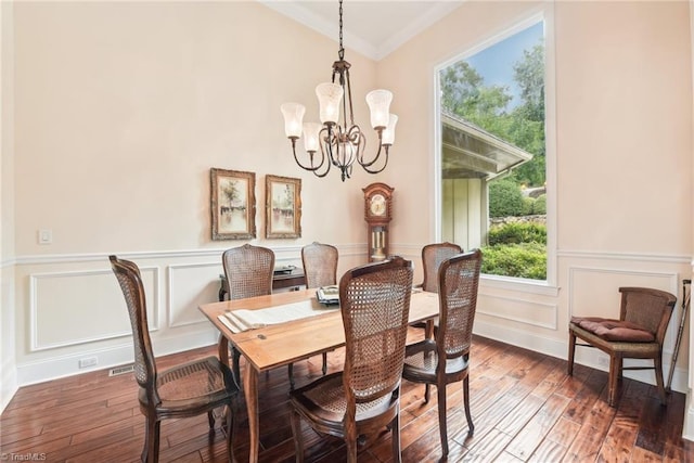 dining area featuring ornamental molding, dark hardwood / wood-style flooring, a wealth of natural light, and a notable chandelier