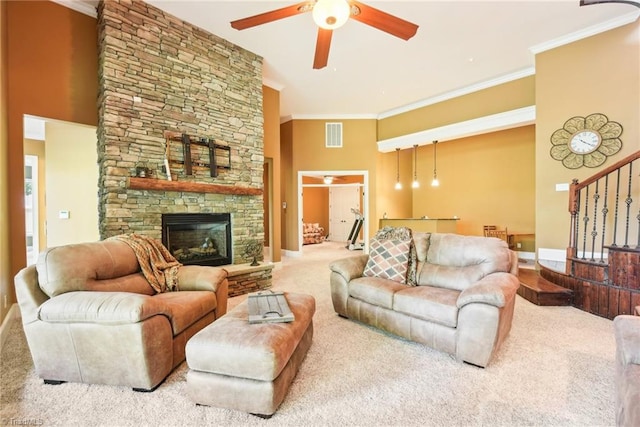 living room featuring ceiling fan, ornamental molding, carpet floors, and a fireplace