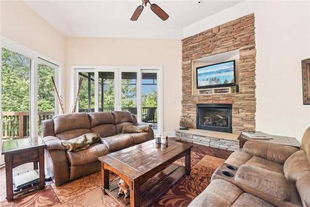 living room featuring light hardwood / wood-style flooring, ceiling fan, and a fireplace