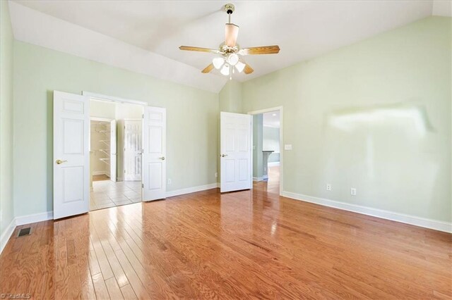 unfurnished bedroom with light wood-type flooring, vaulted ceiling, and ceiling fan