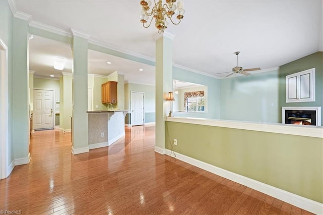 interior space with ceiling fan with notable chandelier, light hardwood / wood-style floors, and crown molding