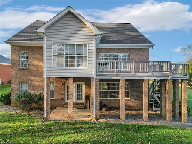 rear view of house featuring a wooden deck, a patio area, and a lawn