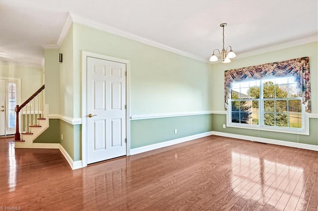 unfurnished room featuring hardwood / wood-style floors, ornamental molding, and a notable chandelier