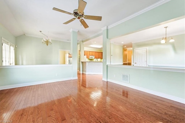 unfurnished room featuring ceiling fan with notable chandelier, ornamental molding, and light hardwood / wood-style floors