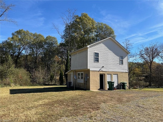 exterior space with central AC unit and a lawn