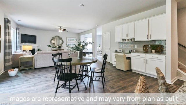 kitchen with white cabinets, ceiling fan, light stone counters, tasteful backsplash, and dark hardwood / wood-style flooring